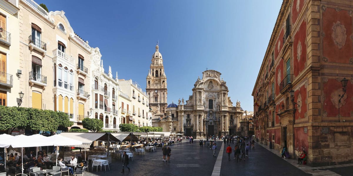 Zonnig plein met de kathedraal van Murcia en terrasjes